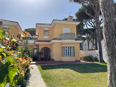 a yellow house with a tree in front of it at Chalet Violeta in Chiclana de la Frontera