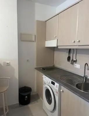 a kitchen with a washing machine and a sink at APART CLUB LABARROSA in Chiclana de la Frontera