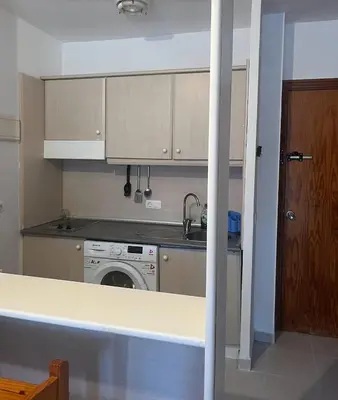 a kitchen with a sink and a washing machine at APART CLUB LABARROSA in Chiclana de la Frontera