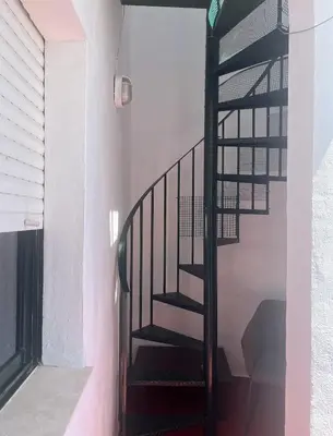 a spiral staircase in a house with a window at APART CLUB LABARROSA in Chiclana de la Frontera