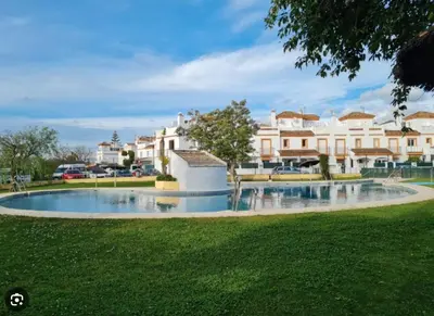 a large swimming pool in a park with buildings at APART CLUB LABARROSA in Chiclana de la Frontera