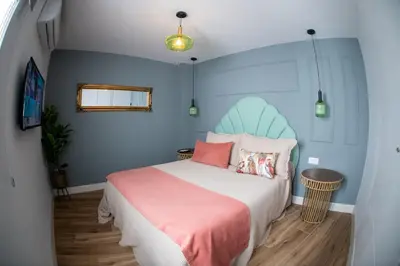 a bedroom with a bed with a blue headboard at Apartamentos Milord in El Puerto de Santa María