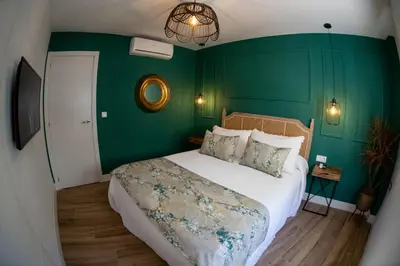 a bedroom with a bed with green walls at Apartamentos Milord in El Puerto de Santa María