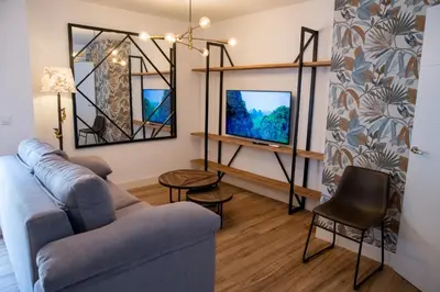 a living room with a couch and a tv at Apartamentos Milord in El Puerto de Santa María