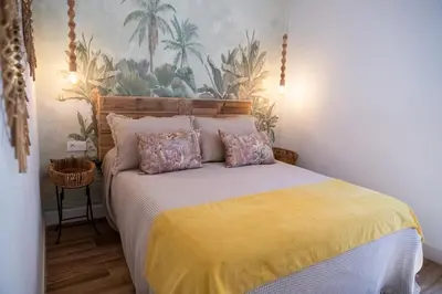 a bedroom with a bed with a yellow bedspread at Apartamentos Milord in El Puerto de Santa María
