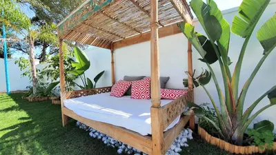 a bed in a gazebo in a garden at Villa Edén, Casa Rural lujo con Chimenea Piscina in Arcos de la Frontera