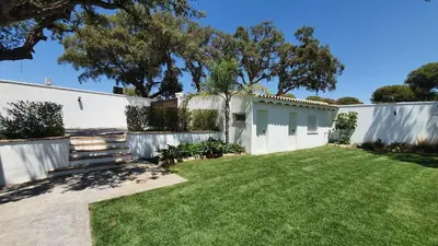 a backyard with a white fence and a grass yard at Villa Edén, Casa Rural lujo con Chimenea Piscina in Arcos de la Frontera