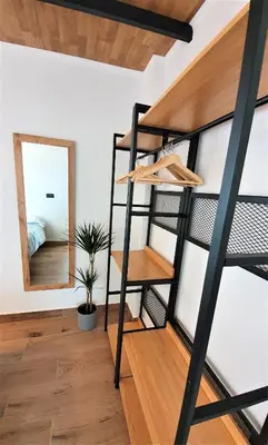 a loft apartment with a ladder and a mirror at Villa Edén, Casa Rural lujo con Chimenea Piscina in Arcos de la Frontera