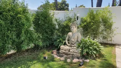 a statue sitting in the grass in a yard at Villa Edén, Casa Rural lujo con Chimenea Piscina in Arcos de la Frontera