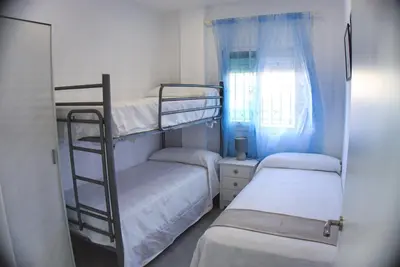 two bunk beds in a small room with a window at Apartamento Vistas de Doñana in Sanlúcar de Barrameda