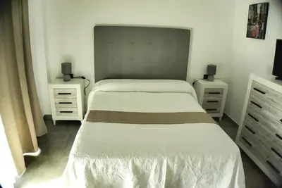a bedroom with two beds and two dressers and a bed sidx sidx sidx sidx at Apartamento Vistas de Doñana in Sanlúcar de Barrameda