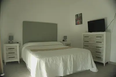 a bedroom with a bed and a dresser with a television at Apartamento Vistas de Doñana in Sanlúcar de Barrameda