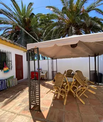 a table and chairs under a white umbrella on a patio at Tierra del Sur in Conil de la Frontera