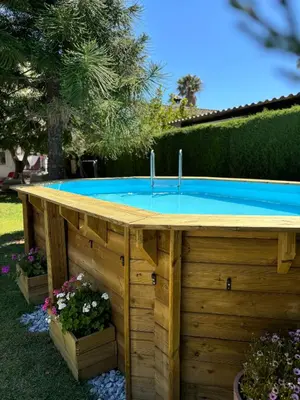 a swimming pool in a backyard with a wooden table at Tierra del Sur in Conil de la Frontera