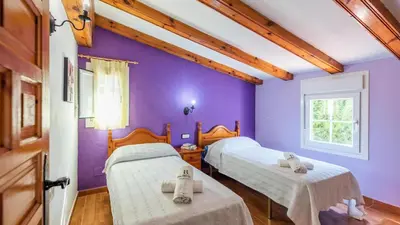 two beds in a room with purple walls at Villa El Cortijo Andaluz Conil de la Frontera by Ruralidays in Conil de la Frontera