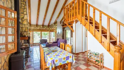 a living room with a wooden staircase and a table at Villa El Cortijo Andaluz Conil de la Frontera by Ruralidays in Conil de la Frontera