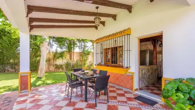 a patio with a table and chairs on a house at Villa El Cortijo Andaluz Conil de la Frontera by Ruralidays in Conil de la Frontera