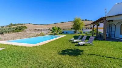a group of chairs sitting next to a swimming pool at Finca Las Encinillas Arcos de la Frontera by Ruralidays in Arcos de la Frontera