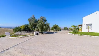 a large gravel road next to a white building at Finca Las Encinillas Arcos de la Frontera by Ruralidays in Arcos de la Frontera