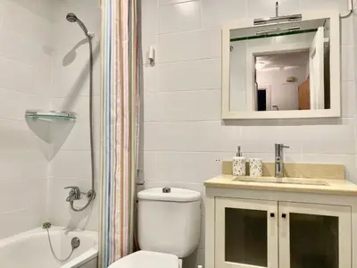 a bathroom with a toilet and a sink and a mirror at APARTAMENTO GENOVEVA PLAYA - Playa, Piscina, Wifi in El Puerto de Santa María