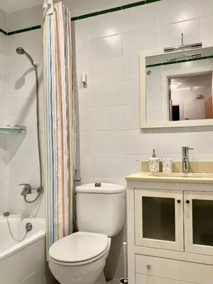 a bathroom with a toilet and a sink and a mirror at APARTAMENTO GENOVEVA PLAYA - Playa, Piscina, Wifi in El Puerto de Santa María
