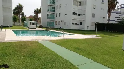 a swimming pool in a yard next to a building at APARTAMENTO GENOVEVA PLAYA - Playa, Piscina, Wifi in El Puerto de Santa María