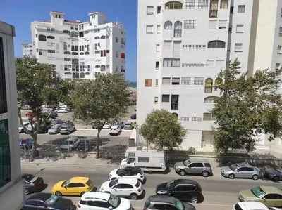 a parking lot with cars parked in front of tall buildings at APARTAMENTO GENOVEVA PLAYA - Playa, Piscina, Wifi in El Puerto de Santa María
