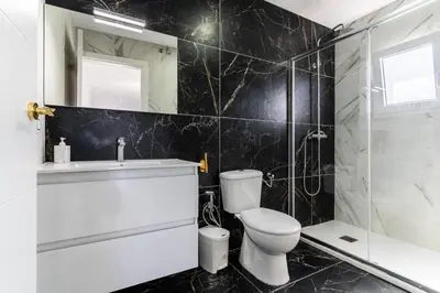 a bathroom with a toilet and a shower and a sink at Casita de la coquina in Chiclana de la Frontera