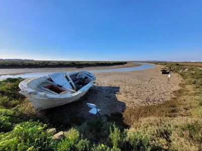 a boat sitting on the shore of a beach at Casita de la coquina in Chiclana de la Frontera