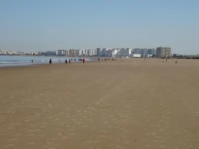 a group of people walking on the beach at Apartamento playa Valdelagrana in El Puerto de Santa María