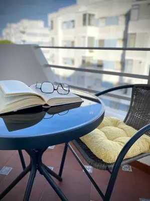 a blue table with a book and glasses on it at MyChoice Carmen in Rota