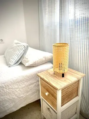 a bedroom with a bed and a lamp on a night stand at MyChoice Carmen in Rota