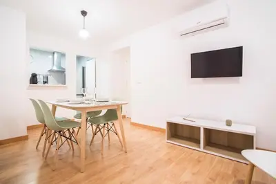 a dining room with a table and chairs and a tv at Apartoyou - Luna Centro in El Puerto de Santa María