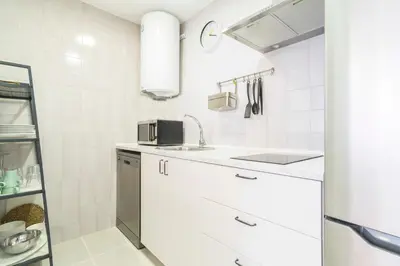 a white kitchen with a sink and a microwave at Apartoyou - Luna Centro in El Puerto de Santa María