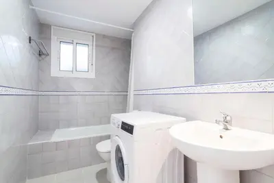 a white bathroom with a sink and a washing machine at Apartoyou - Luna Centro in El Puerto de Santa María