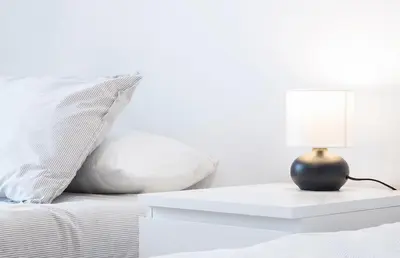 a bed with a table with a lamp on it at Apartoyou - Luna Centro in El Puerto de Santa María