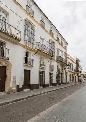 a white building with balconies on a street at Apartoyou - Luna Centro in El Puerto de Santa María