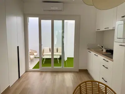 a kitchen with a sliding glass door leading to a patio at Adosado en calle Nereida in Chiclana de la Frontera