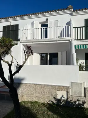 a white house with a balcony and a tree at Adosado en calle Nereida in Chiclana de la Frontera