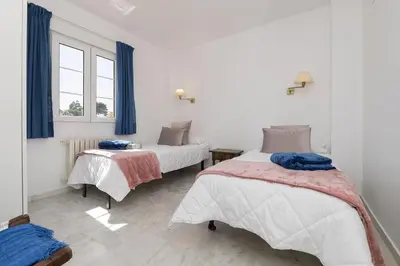 a bedroom with two beds and a window at Los Jandalos in El Puerto de Santa María