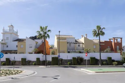 an empty street in front of a building with palm trees at Los Jandalos in El Puerto de Santa María