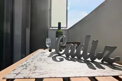 a bottle of wine and a glass on a table at Apartamento San Leonardo Playa (Free Parking) in Cádiz