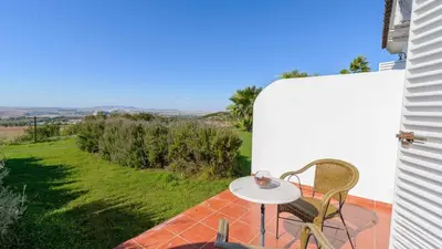 a table and chairs on a patio with a view at Cortijo Escondido Arcos de la Frontera by Ruralidays in Arcos de la Frontera