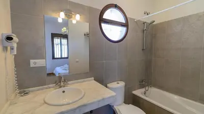 a bathroom with a sink and a toilet and a mirror at Cortijo Escondido Arcos de la Frontera by Ruralidays in Arcos de la Frontera