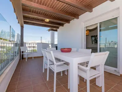 a dining room with a white table and chairs on a balcony at Apartment Punta Candor - Seaview by Interhome in Rota