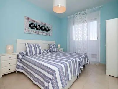 a blue bedroom with a bed and a window at Apartment Punta Candor - Seaview by Interhome in Rota