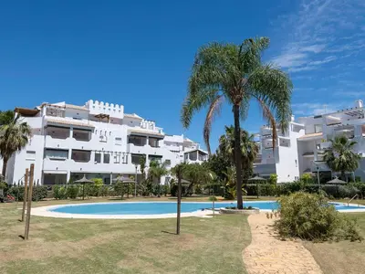 a resort with a palm tree and a swimming pool at Apartment Punta Candor - Seaview by Interhome in Rota