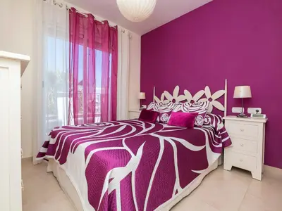 a purple bedroom with a bed with purple walls at Apartment Punta Candor - Seaview by Interhome in Rota