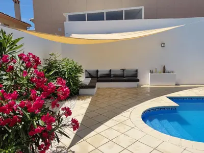 a villa with a swimming pool and pink flowers at Chalet con piscina in San Fernando