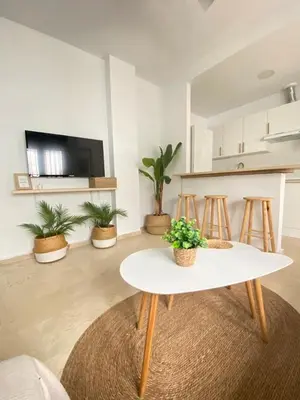 a living room with a table and some plants at Villa Tropical a 2 minutos del Faro de Chipiona in Chipiona